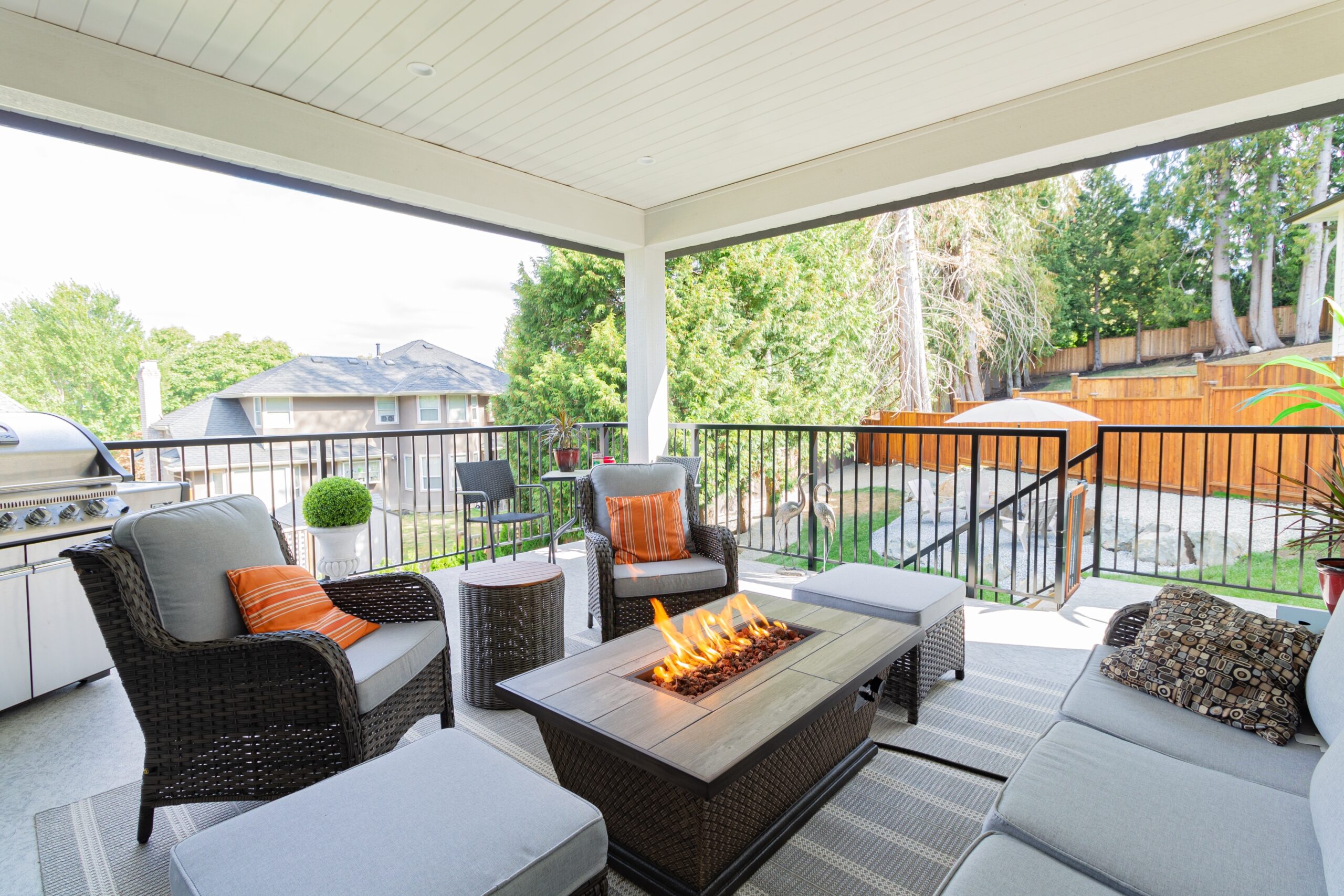 A luxurious spacious deck with stylish patio furniture with a fire pit table heater