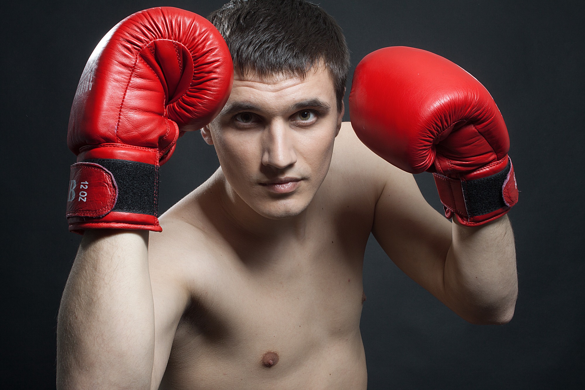 A man wearing boxing gloves strikes a pose for the camera