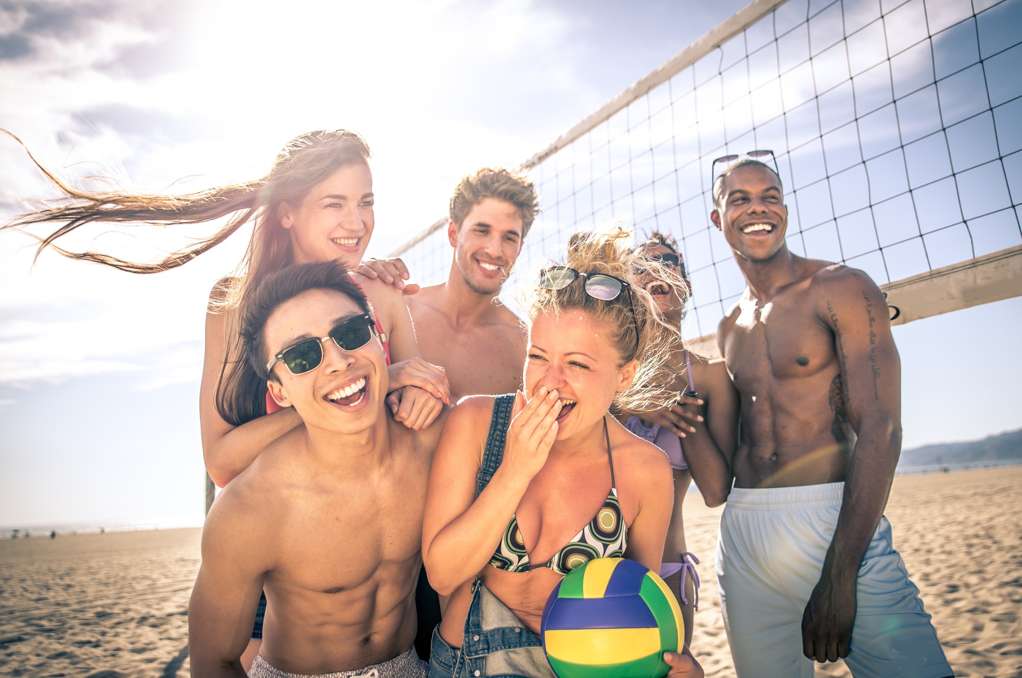 Group of friends playing beach volley on the beach